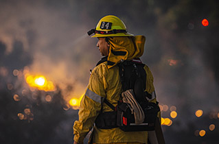 a firefighter standing near a fire