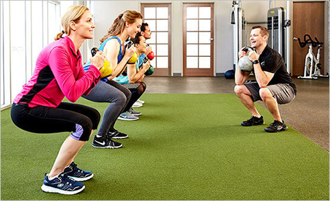 group personal trainer teaching a class with kettlebell